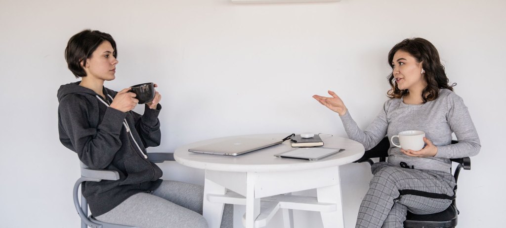 Two women casually talking over coffee.